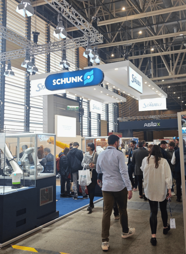 Couloir animé du salon avec exposants et visiteurs